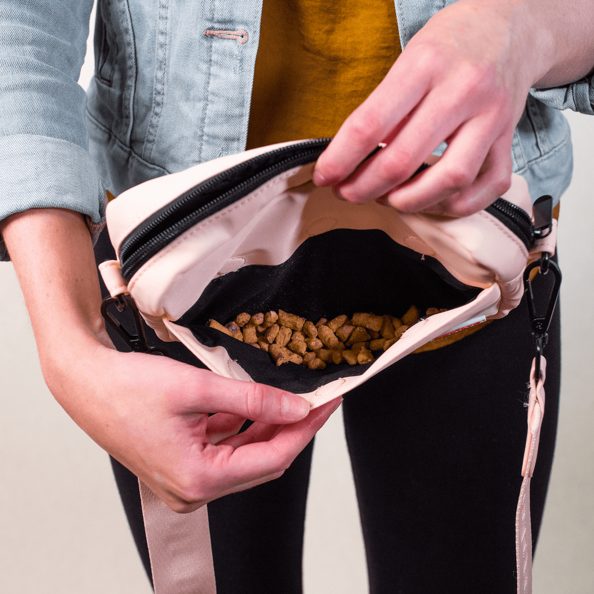 Woman wearing training treat pouch in pink