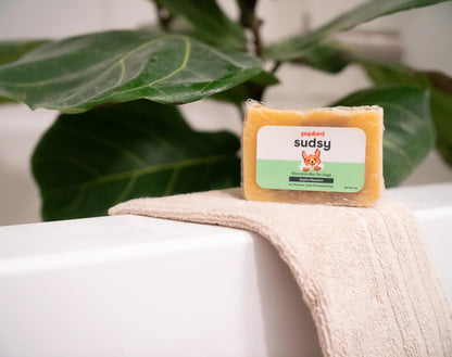 sudsy shampoo bar alpine meadow on the edge of a tub on a towel | Pupford